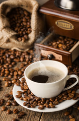 hot coffee and coffee beans on the background of coffee grinders