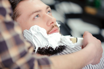 Client shaving at barber shop