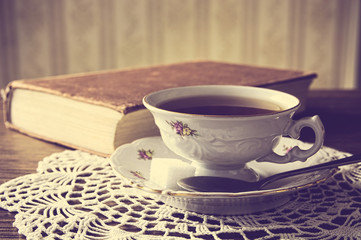 Cup of tea with book on napkin vintage effect