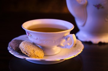 Old-style kettle with cup of tea on black