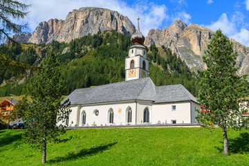 Fototapeta na wymiar Church in Colfosco alpine village, Dolomites Mountains, Italy
