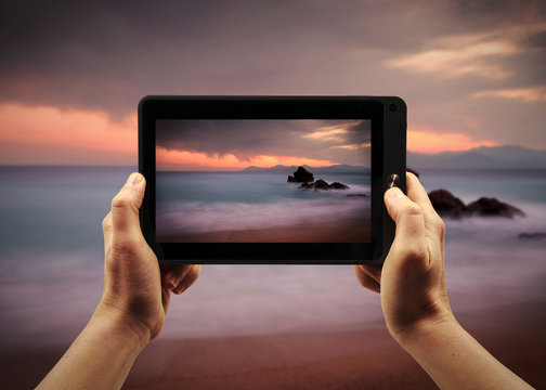 Take a landscape picture with a tablet PC during te sunset