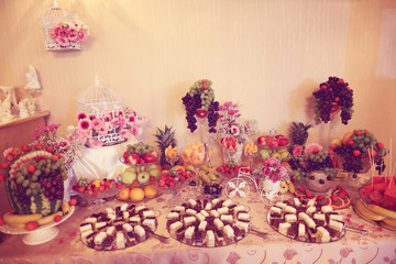 Many sweets and fruit on table