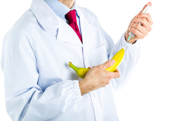 Doctor in white coat making an injection to a banana