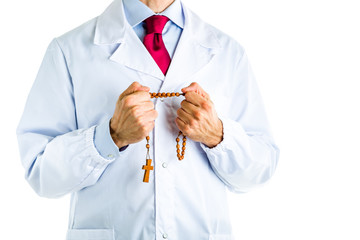 Doctor in white coat holding wooden Rosary beads