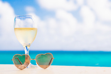 glass of chilled white wine on table near the beach