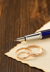 Fototapeta premium wedding ring and aged paper on wood