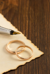 wedding ring and aged paper on wood