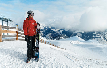 Male snowboarder against winter mountains background