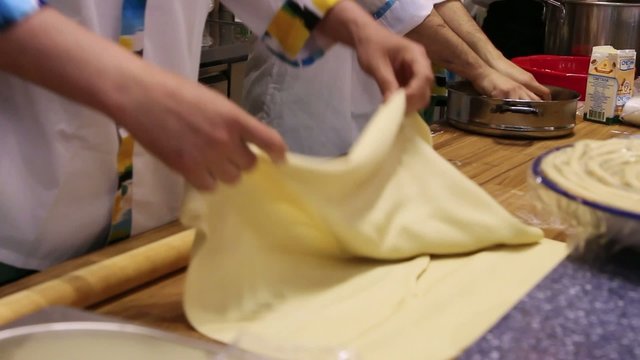 male chefs hands preparing dough with rolling pin for asian food