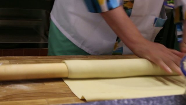male chefs hands preparing dough with rolling pin for asian food