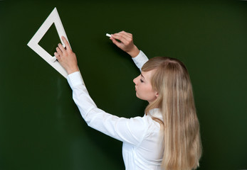 girl at a school board with chalk