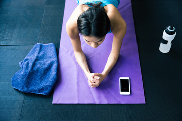 Young woman doing yoga exercises on yoga mat