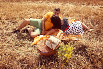 Couple laying on grass having picnick