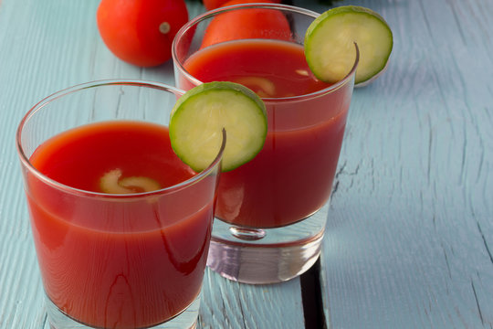 Tomato gazpacho in glasses over blue wooden table