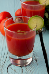 Tomato gazpacho in glasses over blue wooden table