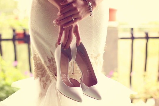 Bride holding her shoes