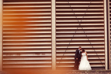 Bride and groom against a striped wall