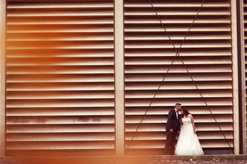 Bride and groom against a striped wall