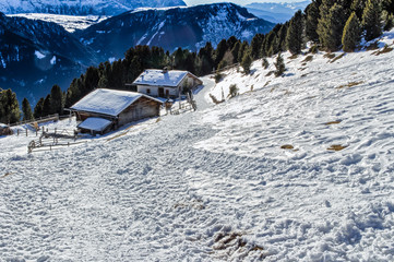 panorama of the Dolomites with wood cottage, snowy mountains and