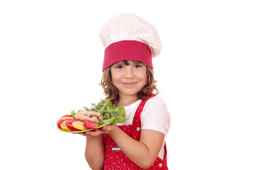 happy little girl cook with prepared salmon