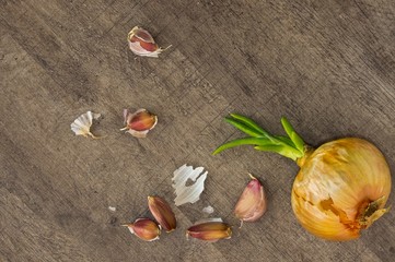 onion and garlic cloves on a wooden table