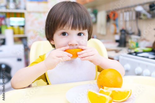 "Little child eats orange" Stock photo and royalty-free images on