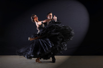 Dancers in ballroom at black background