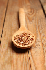 Buckwheat in a spoon on a wooden table
