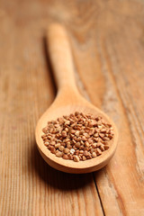 Buckwheat in a spoon on a wooden table