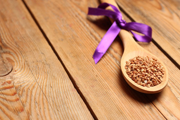 Buckwheat in a spoon on a wooden table
