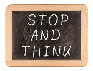 Obraz premium The phrase Stop and Think written on a blackboard as a reminder