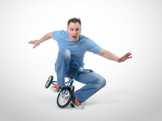 Curious man on a children's bicycle on white background