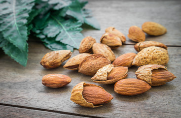 Almond with leaves on wooden table