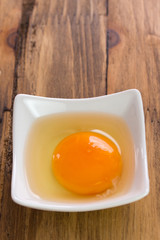 raw egg in white bowl