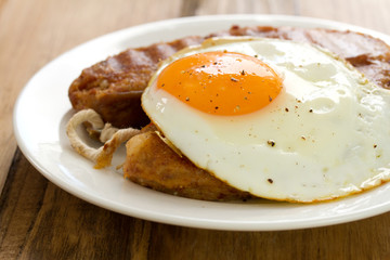 fried alheira with egg on white plate