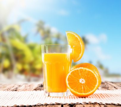  Orange juice on wooden with tropical beach 