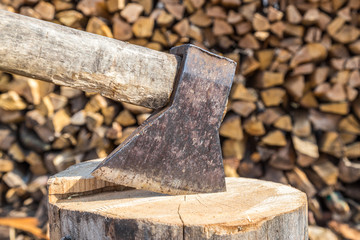 Axe head closeup on a wooden log