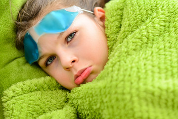 sick child girl under a blanket