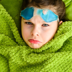 Sick child girl under a blanket