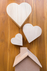 wooden house and heart on brown wood background