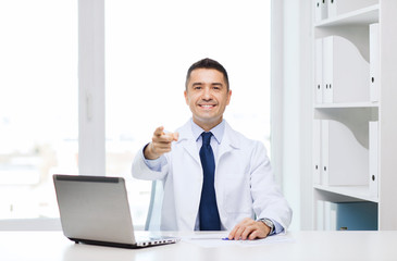 Naklejka premium smiling doctor pointing finger at you in office