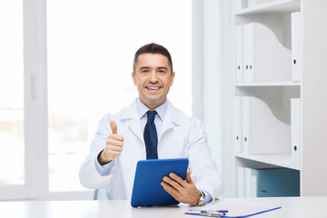 smiling doctor with tablet pc showing thumbs up