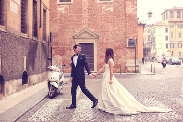 Bride and groom walking on paved road
