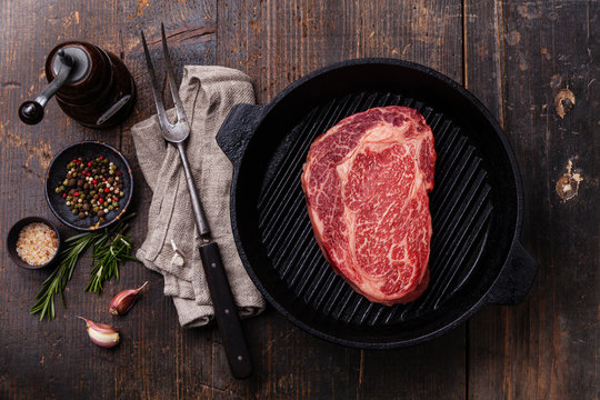Raw fresh Black Angus Steak on grill pan on wooden background