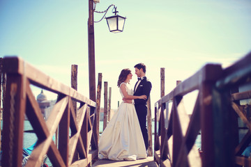 Bride and groom on wooden bridge