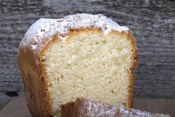Cake with raisin and sugar powder on the wooden table. Selective