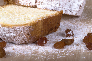 Cake with raisin and sugar powder on the wooden table. Selective