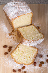 Cake with raisin and sugar powder on the wooden table. Selective