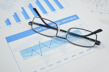 Glasses on financial chart and graph, vision concept